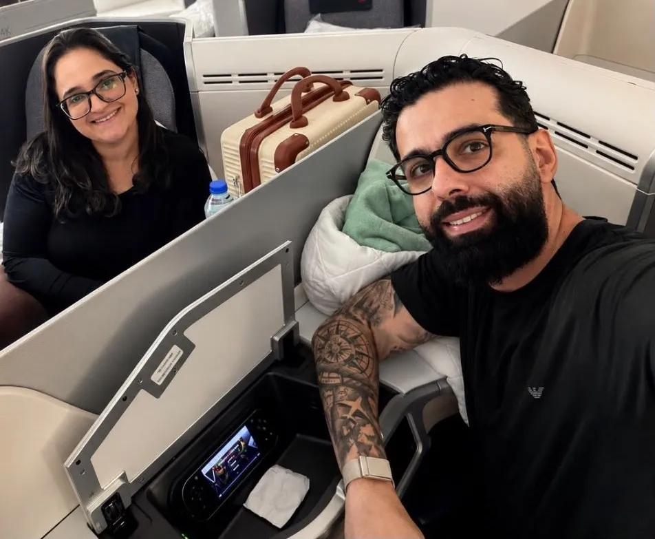 Casal sorrindo nas poltronas da classe executiva